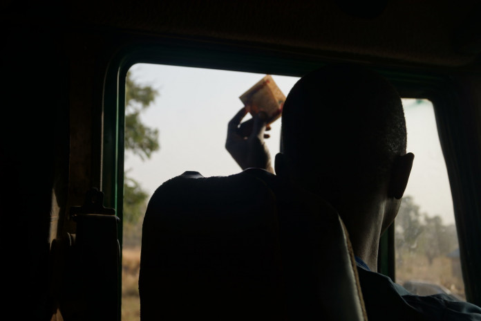 Part 2 Report - Truck driver raising N500 bill for Nigeria Immigration officials along Benue route. Picture by Ibanga Isine INVESTIGATION: How bribe-taking security operatives, gangs force Nigerians to pay dearly for food (PART 2)